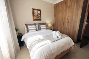 a bedroom with a large bed with towels on it at AllesWells in Yzerfontein