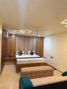 a bedroom with a bed and two seats in it at Hotel Manoj in Bhopal