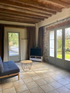 a living room with a couch and a tv at Gîte Asaliah in Sainte-Colome