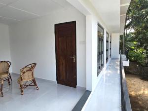 a hallway with a door and chairs in a house at Royal Star Guest House in Jaffna