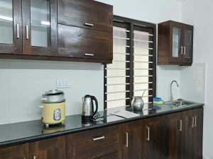 a kitchen with wooden cabinets and a appliance on a counter at Royal Star Guest House in Jaffna