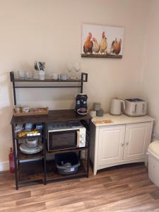 a kitchen with a counter with a microwave and chickens on the wall at Carnach in Fort William