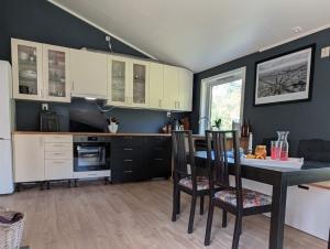 a kitchen with a table and chairs in a room at Rasteplassen in Stordalen