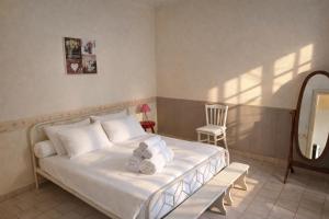 a bedroom with a bed with a chair and a mirror at LES CHESNEAUX in Loches
