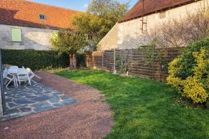 a backyard with a brick fence and a table and chairs at LES CHESNEAUX in Loches