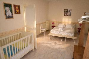 a bedroom with a white bed and a crib at LES CHESNEAUX in Loches +14 photos
