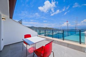 a balcony with a table and chairs and a view of the water at Körfez Apart in Fethiye