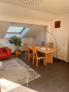 a dining room with a table and a red couch at Modern Apartment in Annemasse 15 mins to Geneva with private free parking in Vétraz-Monthoux +7 photos