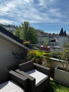a balcony with two chairs and a table on a balcony at Modern Apartment in Annemasse 15 mins to Geneva with private free parking in Vétraz-Monthoux