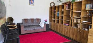 a living room with a chair and a red rug at Brighton Hostel Stays in Sultan Bathery