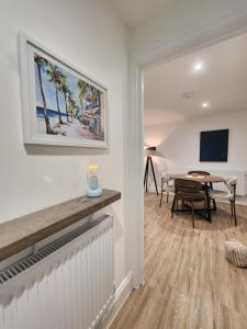 a living room with a table and a television at Seashell Retreat in Bournemouth