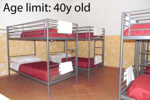 a room with three bunk beds with red sheets at Agorà Hostel in Pompei