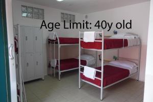 a room with three bunk beds with red and white at Agorà Hostel in Pompei