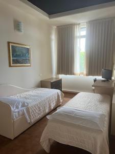 a hotel room with two beds and a window at G&D Winter Home in Milano Marittima