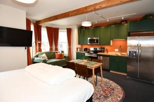 a room with a bed and a kitchen with green cabinets at HighRoad Washington DC in Washington, D.C.