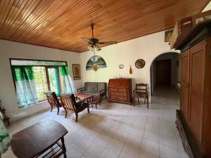 a living room with a table and chairs and a ceiling at Hill Side Kings Villa (Colonial Bungalow) in Hikkaduwa