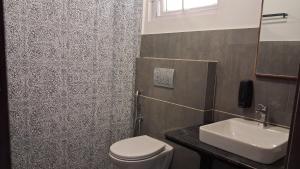 a bathroom with a toilet and a sink at Vidman Homey Huts in Tindummal