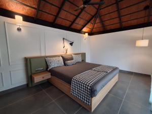 a bedroom with a bed and a wooden ceiling at Vidman Homey Huts in Tindummal