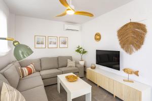 a living room with a couch and a tv at AT Ponent I B3 in La Playa de la Torre de Piles