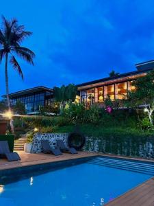 a house with a swimming pool in front of a house at Jinjer Resort in Cavinti