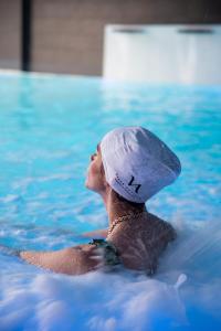 a woman in a swimming pool with a cap on at Hotel & Thalasso Villa Antilla - Habitaciones con Terraza - Thalasso incluida in Orio