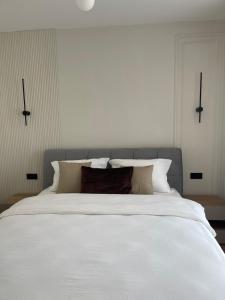 a large white bed with white sheets and pillows at Cashmere Apartment in Cluj-Napoca