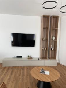 a living room with a tv and a table at Cashmere Apartment in Cluj-Napoca