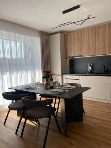 a kitchen with a black table and chairs in a room at Cashmere Apartment in Cluj-Napoca