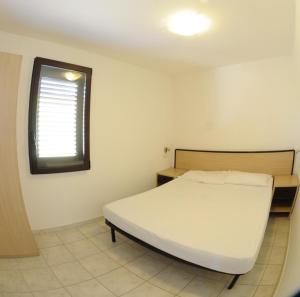 a bedroom with a white bed and a window at Villaggio Santo Stefano in Vieste +74 photos