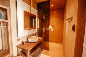 a bathroom with a sink and a wooden table at Sunset at Las Cabanas in El Nido