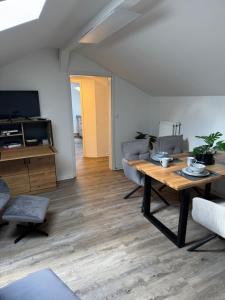 ein Wohnzimmer mit einem Holztisch und Stühlen in der Unterkunft Apartment Oberdeck für 4 Personen, Wifi, Parkplätze uvm in Brokstedt