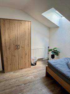 ein Schlafzimmer mit einem großen Holzschrank und einem Bett in der Unterkunft Apartment Oberdeck für 4 Personen, Wifi, Parkplätze uvm in Brokstedt