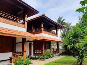a building with a balcony and a yard at SUN VIEW Beach Resort in Varkala