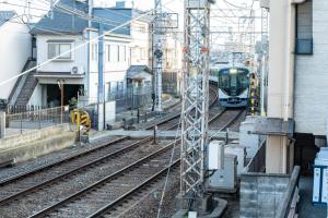 a train on the tracks next to a building at 狐狐 Coco in Kyōto