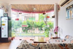 a living room with a large window and a couch at NamRoom at Margot Jaksa in Jakarta