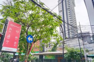 a sign on a street in a city with skyscrapers at NamRoom at Margot Jaksa in Jakarta