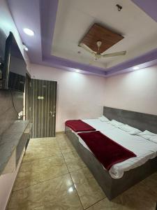 a bedroom with a bed and a television in it at Shree Kulluka Guest House Ujjain in Ujjain