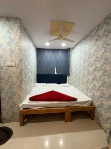 a bedroom with a bed with a red blanket on it at Shree Kulluka Guest House Ujjain in Ujjain