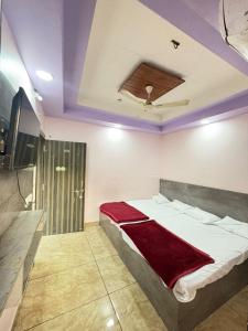 a bedroom with a bed with a red blanket on it at Shree Kulluka Guest House Ujjain in Ujjain