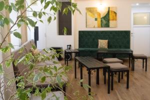 a waiting room with a green couch and tables at Hotel Hayat in Sarajevo