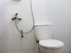 a bathroom with a toilet with a shower at RedDoorz @ Seturan Raya in Yogyakarta