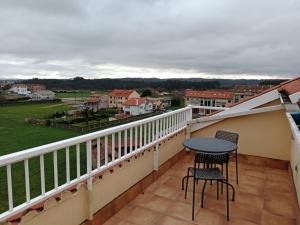 a balcony with a table and chairs and a view at Pension Ameneiral in O Pedrouzo