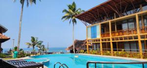 a resort with a swimming pool next to the ocean at SUN VIEW Beach Resort in Varkala