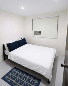 a bedroom with a white bed and a window at Ben & Ben - Unit 2 in Cebu City