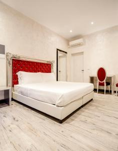 um quarto com uma cama grande e uma cabeceira vermelha em Arena Easy Suites Guesthouse em Verona