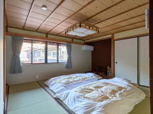 a large bed in a room with a wooden ceiling at The Cross Inn Gujo in Gujo
