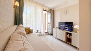 a living room with a couch and a flat screen tv at Bratanov Harmony Monte Carlo in Sunny Beach