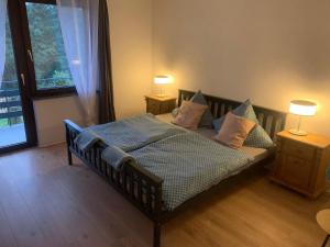 a bedroom with a bed with pillows and two lamps at Ferienwohnung Schimpf in Sosberg