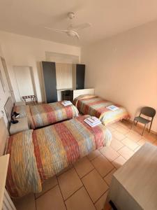 a hotel room with two beds and a table at Albergo Roma in Gattico +56 photos