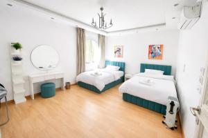 a bedroom with two beds and a mirror at Elegant Hydepark Apt With Garden in New cairo